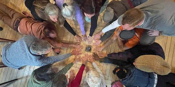 Experience Week participants with their hands in a circle