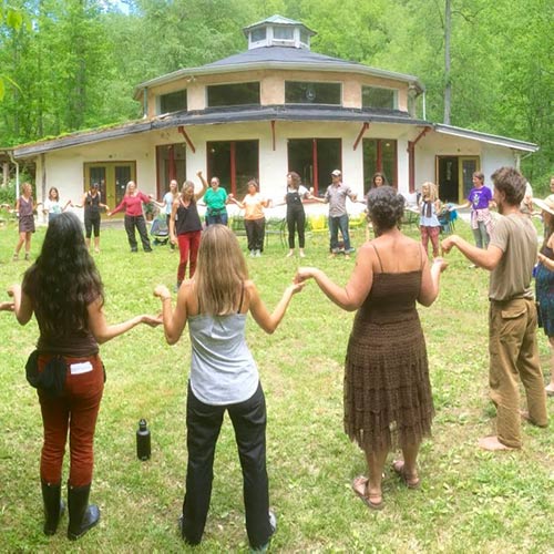 Group circling in front of the Earthaven Ecovillage Council Hall